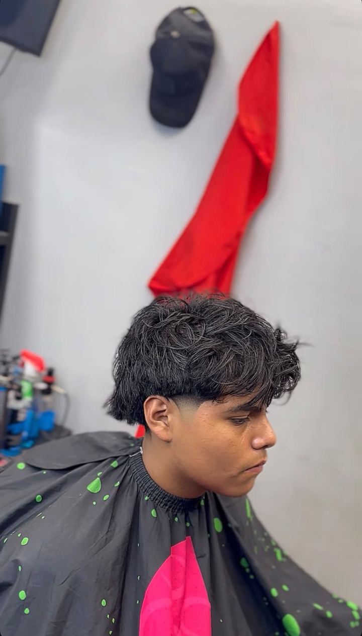Client with a messy textured top and a taper fade, shown from the side